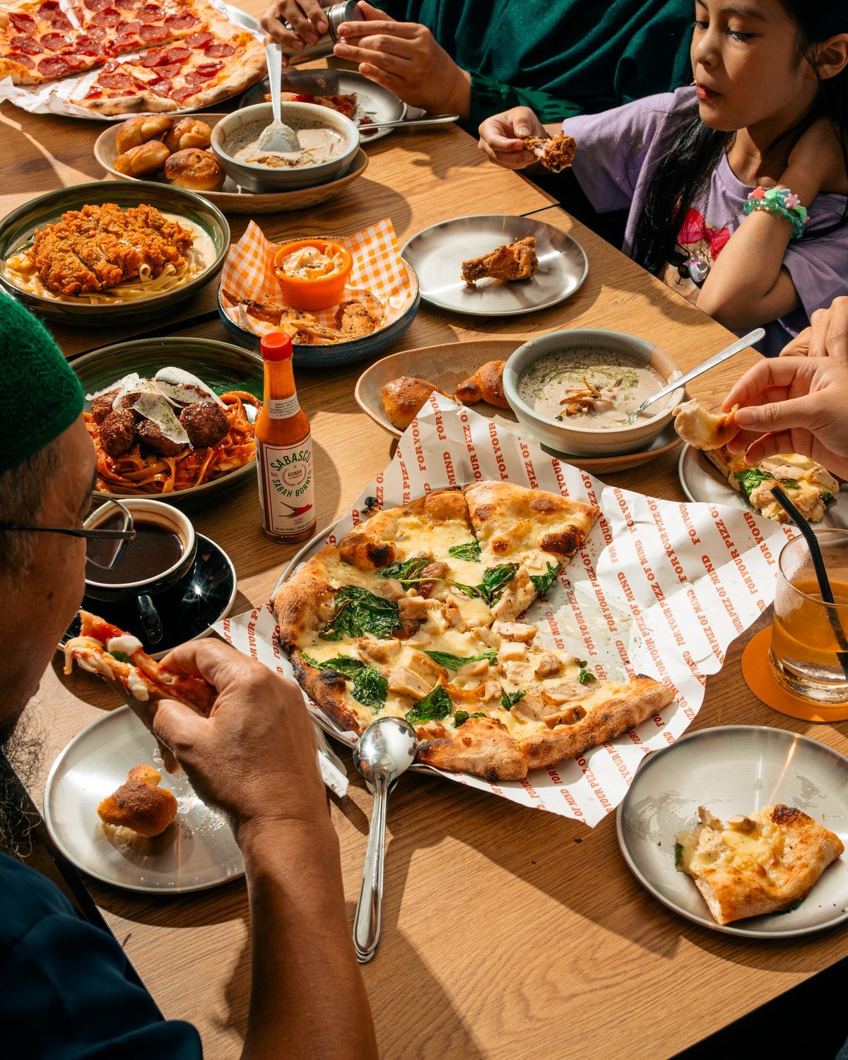 Table of shared pizzas and side dishes at Mokky's Pizza