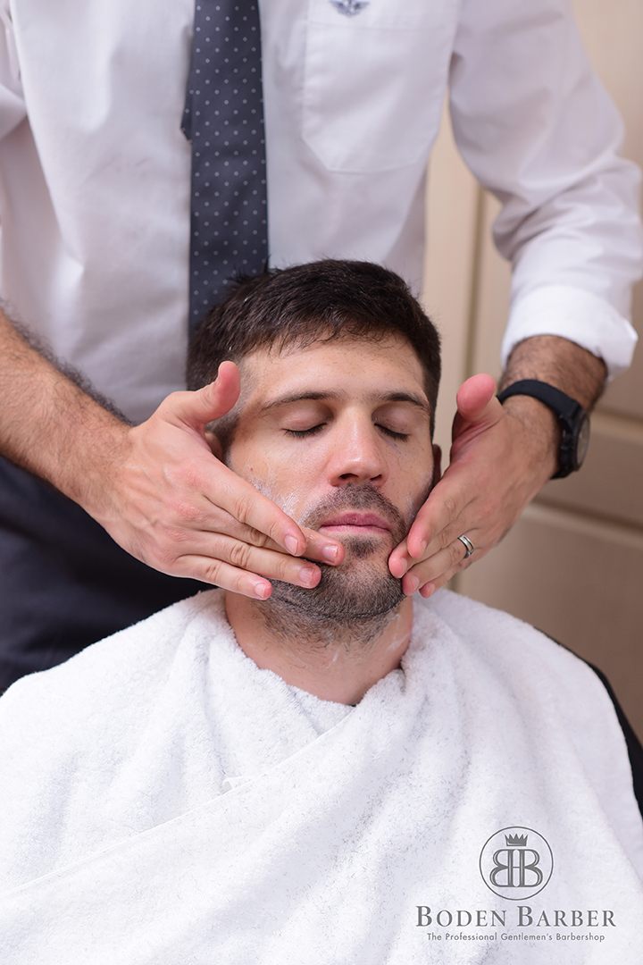 Barber giving a client a hot towel shave at Boden Barber